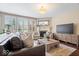 Cozy living room featuring fireplace, neutral furniture, and plenty of natural light from the large windows at 2705 April Springs View, Carmel, IN 46074