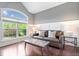 Bright living room featuring a large window, dark wood floors and a comfortable brown leather sofa at 2705 April Springs View, Carmel, IN 46074