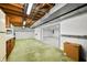 Basement area with carpet, featuring wood cabinets, exposed ceiling, and connection to upper floors at 273 N Serenity Way, Greenwood, IN 46142