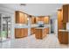 Bright kitchen with tile floors, wood cabinets, an island, and white appliances at 273 N Serenity Way, Greenwood, IN 46142