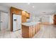 Spacious kitchen with tile flooring and an island with wood cabinets and a white refrigerator at 273 N Serenity Way, Greenwood, IN 46142