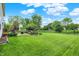 Landscaped backyard with a patio, outdoor seating, mature trees, and a well-manicured lawn, ideal for gatherings at 286 Fairfax Ln, Greenwood, IN 46142