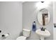 Clean half-bath with pedestal sink, round mirror, and modern fixtures at 286 Fairfax Ln, Greenwood, IN 46142