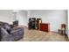 Comfortable living space with stylish wood flooring, a brown leather couch, and adjacent dining area at 286 Fairfax Ln, Greenwood, IN 46142
