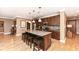 Open kitchen with dark wood cabinets, granite countertops, a kitchen island with seating and pendant lighting at 333 Massachusetts Ave # 303, Indianapolis, IN 46204