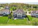 A high angle view of the house showing the deck, the patio with fire pit, outdoor kitchen and grassy lawn at 3384 Homestretch Dr, Carmel, IN 46032