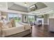 Luxurious bedroom featuring a tray ceiling, hardwood floors, a fireplace and ample natural light from large windows at 3384 Homestretch Dr, Carmel, IN 46032