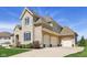 Spacious three-car garage with a paved driveway, enhanced by a blend of stone and brick exterior at 3384 Homestretch Dr, Carmel, IN 46032