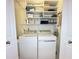Laundry room with white washer, dryer, and shelving for storage at 355 E Ohio St # Ste 105, Indianapolis, IN 46204