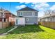 View of fenced backyard with green grass and a light blue house on a sunny day at 3628 N Illinois St, Indianapolis, IN 46208