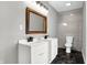 Bathroom featuring a modern design with tiled walls, a black marble floor, a wood framed mirror and double sinks at 3628 N Illinois St, Indianapolis, IN 46208
