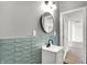 Modern bathroom features a round mirror, trendy blue subway tile, and a bright white vanity at 3628 N Illinois St, Indianapolis, IN 46208