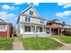 Charming two-story home featuring a covered front porch and a well-manicured lawn at 3628 N Illinois St, Indianapolis, IN 46208