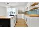Bright kitchen featuring white cabinets, butcher block countertops, and a stylish blue tile backsplash at 3628 N Illinois St, Indianapolis, IN 46208