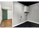 Laundry room featuring a painted green barn door, white cabinet, and black tile floor at 3628 N Illinois St, Indianapolis, IN 46208