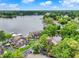 An aerial view of lakefront homes with well-maintained lawns and docks, surrounded by lush greenery and clear blue skies at 3646 Beach Blvd, Cicero, IN 46034