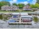 An aerial view featuring multiple townhomes with boat docks on a lake with multiple boats and green lawns at 3646 Beach Blvd, Cicero, IN 46034