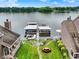 An aerial view shows a backyard with a lake and boat dock, landscaping with a stone path and a table in the center at 3646 Beach Blvd, Cicero, IN 46034