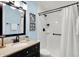 Well-lit bathroom featuring a black framed mirror, modern fixtures, and walk-in shower with curtains at 3646 Beach Blvd, Cicero, IN 46034
