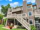 A low angle view of an exterior elevation of a brown townhome with multiple decks, white railings, and stairs leading to a patio at 3646 Beach Blvd, Cicero, IN 46034