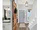 Bright foyer featuring a sliding barn door, bathroom, and hardwood floors leading to the staircase at 3646 Beach Blvd, Cicero, IN 46034