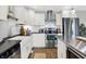 Bright kitchen boasts white cabinets, subway tile backsplash, and stainless steel appliances with a stainless island at 3646 Beach Blvd, Cicero, IN 46034