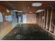 View of unfinished garage interior with exposed studs, utility connections, and dark concrete floor at 3755 N Brentwood Ave, Indianapolis, IN 46235