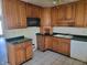 Kitchen space featuring dark countertops, cabinetry, appliances and tile flooring at 3755 N Brentwood Ave, Indianapolis, IN 46235