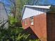 Side view of brick home, highlighting the white trim and green foliage at 3755 N Brentwood Ave, Indianapolis, IN 46235