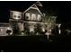 Exterior view of home at night featuring landscape lighting, stone facade, and two car garage at 4205 Hunt Club Pkwy, Bargersville, IN 46106