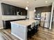 Modern kitchen with stainless steel appliances, island with seating, and dark wood cabinets at 4205 Hunt Club Pkwy, Bargersville, IN 46106