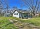 Charming home with green accents, a quaint porch, and a detached garage nestled in a lush yard at 4520 Clinton St, Indianapolis, IN 46226