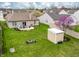 Aerial view of the home featuring a large yard with patio, fire pit, and storage shed, set among neighboring houses at 4729 Beach Club Dr, Noblesville, IN 46062