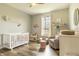 Bedroom room features a crib, rocking chair, and natural light filled window with hardwood flooring at 4729 Beach Club Dr, Noblesville, IN 46062