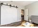 ' room features a sliding barn door and open doorway to an adjacent space with durable, stylish laminate flooring at 4729 Beach Club Dr, Noblesville, IN 46062