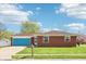 Charming red brick home featuring a blue garage door and manicured lawn under a blue sky at 4905 Candy Spots Dr, Indianapolis, IN 46237