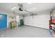 Spacious garage with speckled floor, white garage door, and side door to the house at 4905 Candy Spots Dr, Indianapolis, IN 46237