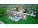Aerial view of home showcasing the backyard pool, patio, deck, and well-manicured lawn in a verdant neighborhood at 4977 Beechwood Rd, Avon, IN 46123