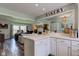 Open-concept kitchen with white cabinets, breakfast bar, and a view into the living area at 4977 Beechwood Rd, Avon, IN 46123