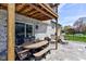 Covered outdoor patio featuring a dining area and lounge chairs with access to the backyard at 4977 Beechwood Rd, Avon, IN 46123