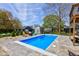 Backyard pool featuring a stamped concrete surround, colorful seating, and a shed in a fenced yard at 4977 Beechwood Rd, Avon, IN 46123