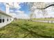 Large backyard featuring lush grass, trees, a pond, and a view of the home's rear exterior at 5007 Avian Ln, Indianapolis, IN 46235