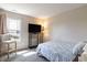 Cozy bedroom features a comfortable bed, a large window, a TV, and a reading chair at 5007 Avian Ln, Indianapolis, IN 46235