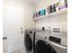 Modern laundry room features new front load washer and dryer and shelving above machines at 5007 Avian Ln, Indianapolis, IN 46235
