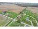 This aerial view shows the house and adjacent properties along a quiet rural street with nearby farmland at 5551 W 200 N, Greenfield, IN 46140