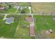 A high angle aerial view displays the house, and surrounding green lawns, tree coverage and neighborhood homes at 5551 W 200 N, Greenfield, IN 46140