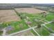 An aerial image shows the house and nearby homes with their spacious lawns, surrounding farm land and forest at 5551 W 200 N, Greenfield, IN 46140