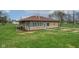 Side view of a stone home with green lawn, surrounded by mulch landscaping, and white trim windows at 5551 W 200 N, Greenfield, IN 46140