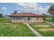 Charming stone home with a red roof, well-maintained lawn and walkway leading to the front door at 5551 W 200 N, Greenfield, IN 46140