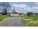 Detached white garage with ample parking space, surrounded by lush greenery at 5551 W 200 N, Greenfield, IN 46140